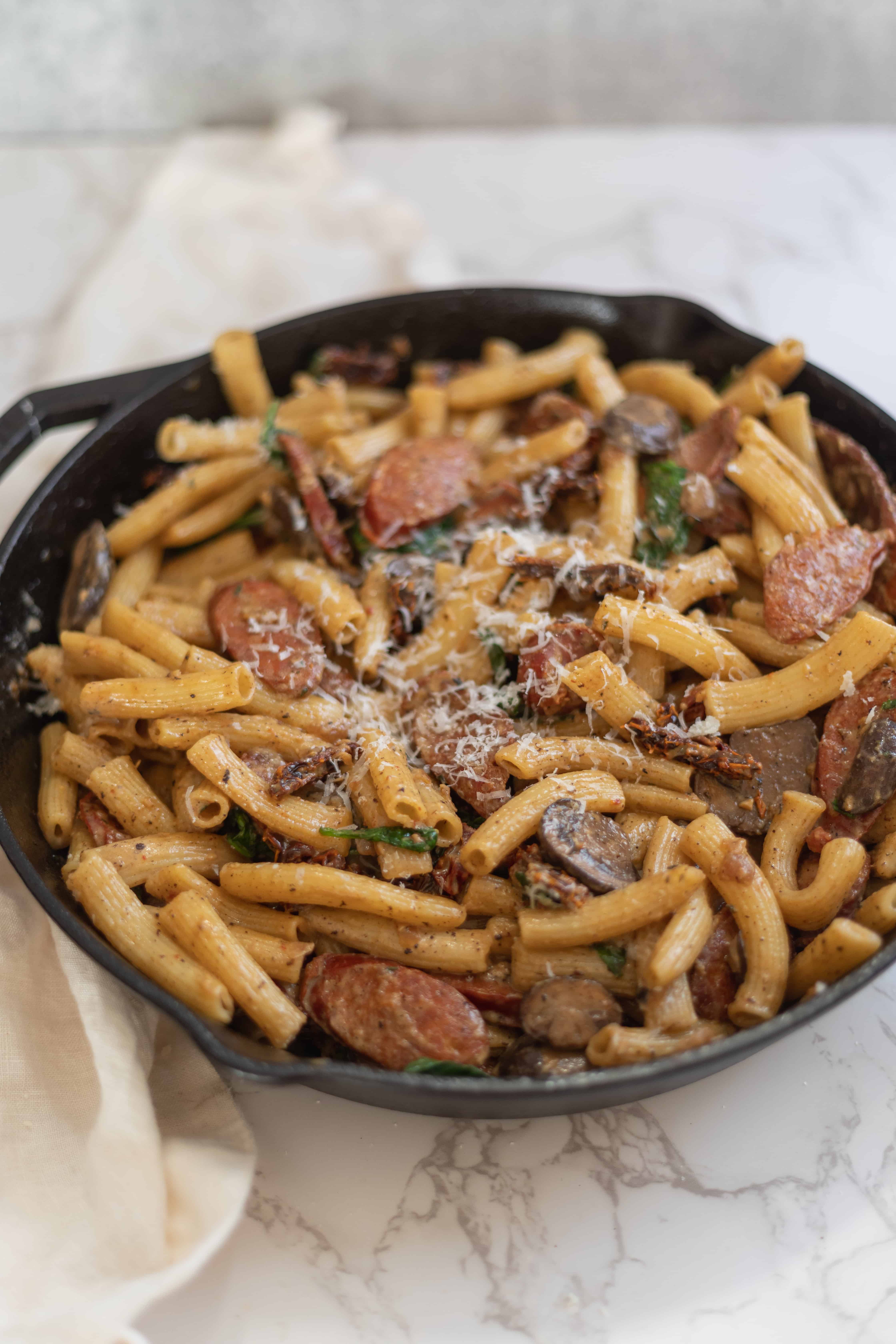 a dutch oven of rigatoni with linguica and sun dried tomatoes