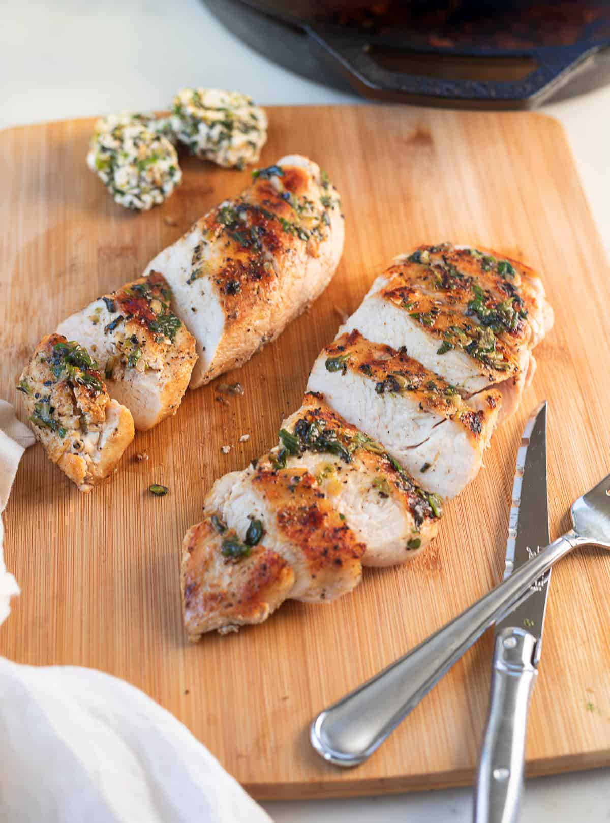 sliced chicken breasts with charred scallion butter on top