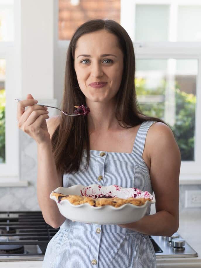 woman eating pie looking at camera