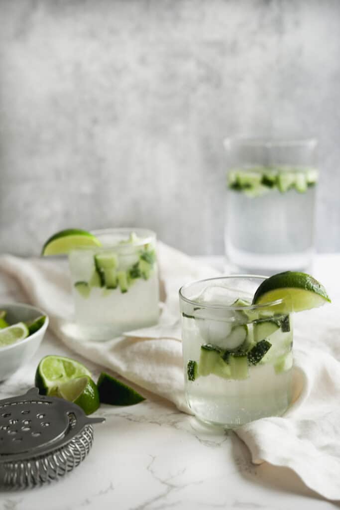 cucumber smash cocktails with lime garnish and pitcher