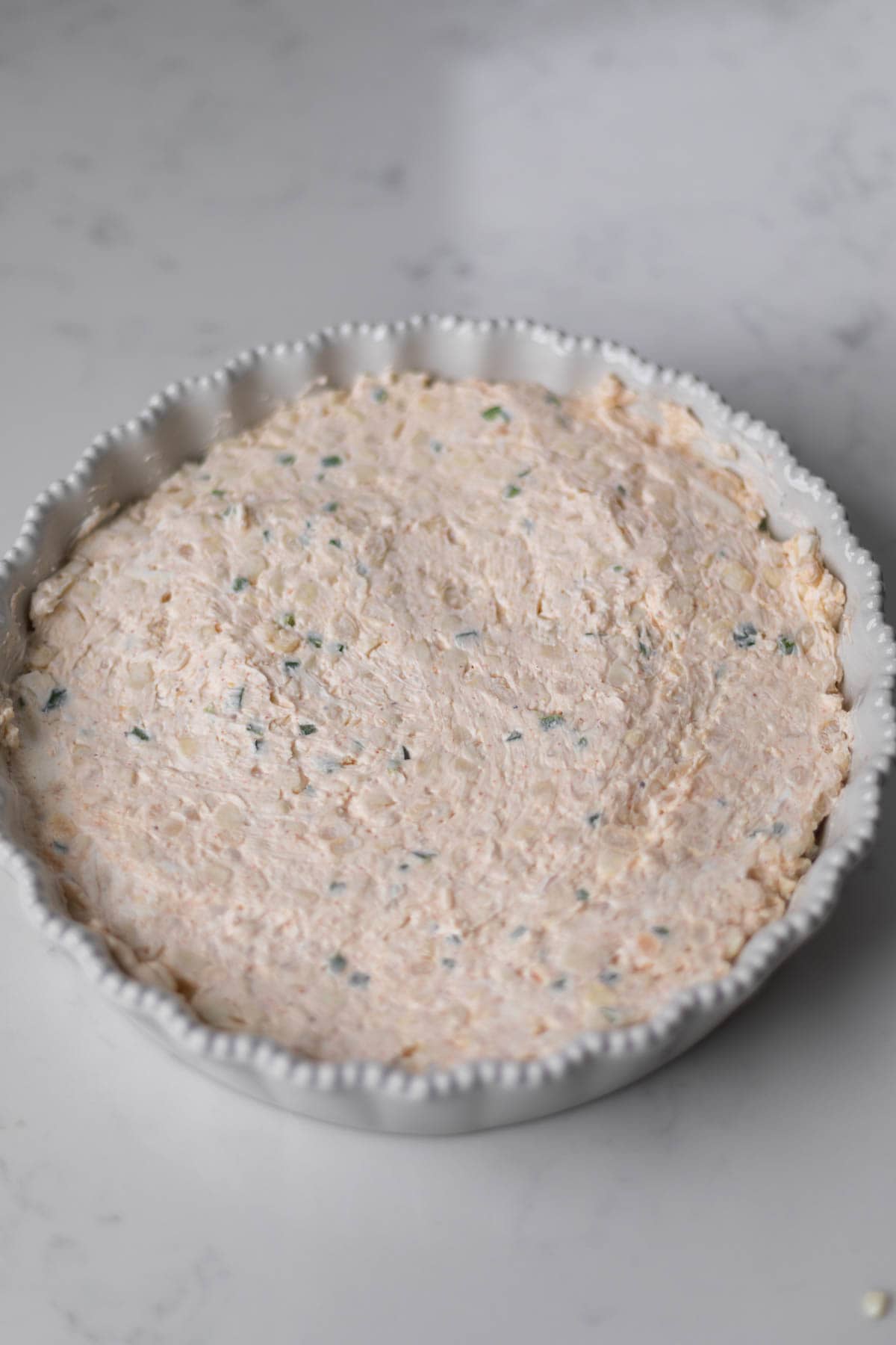 dip ingredients uncooked in a white tart pan