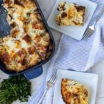 two white plates of breakfast strata next to the casserole of strata and parsley