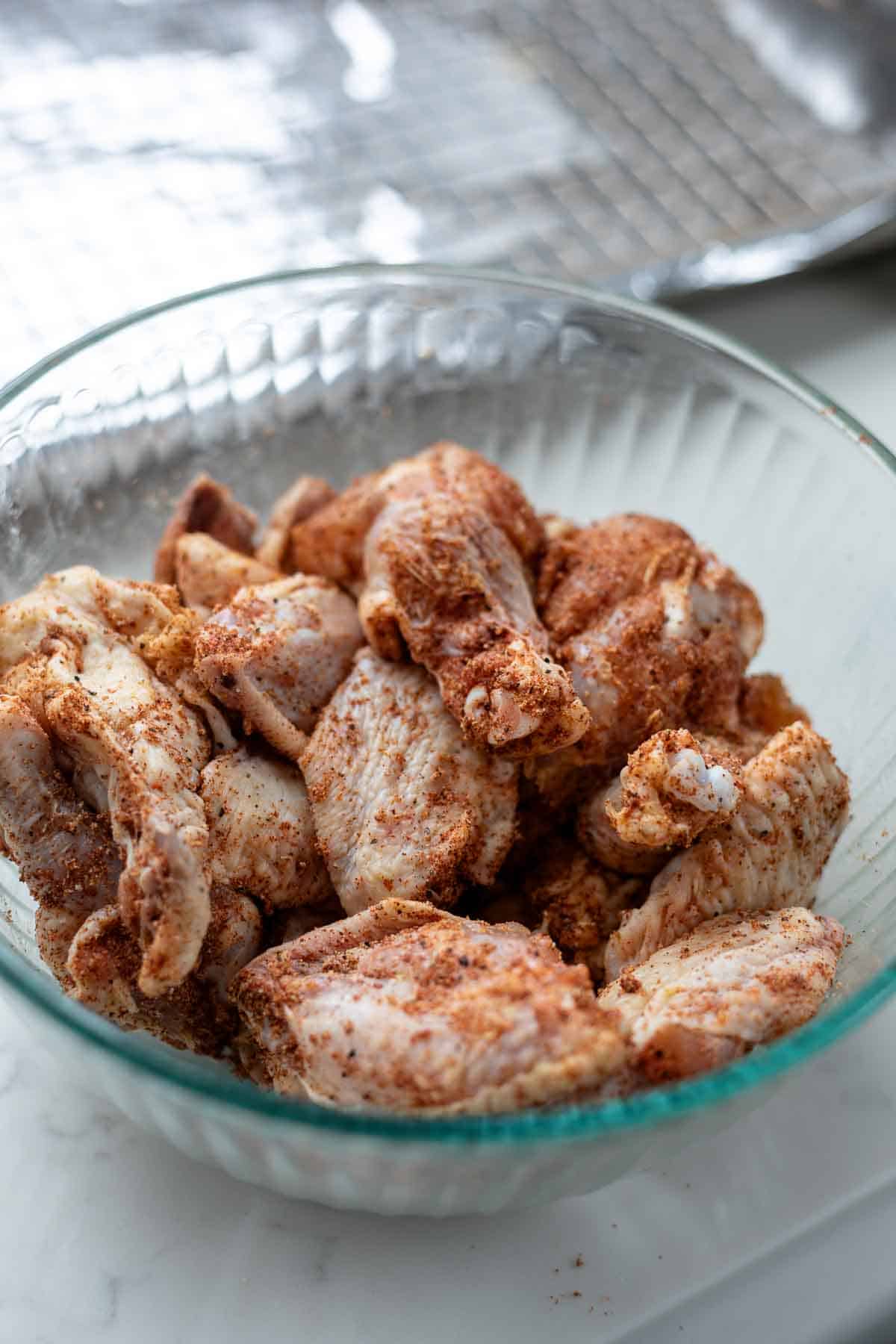 Chicken wings in a bowl coated in spices.